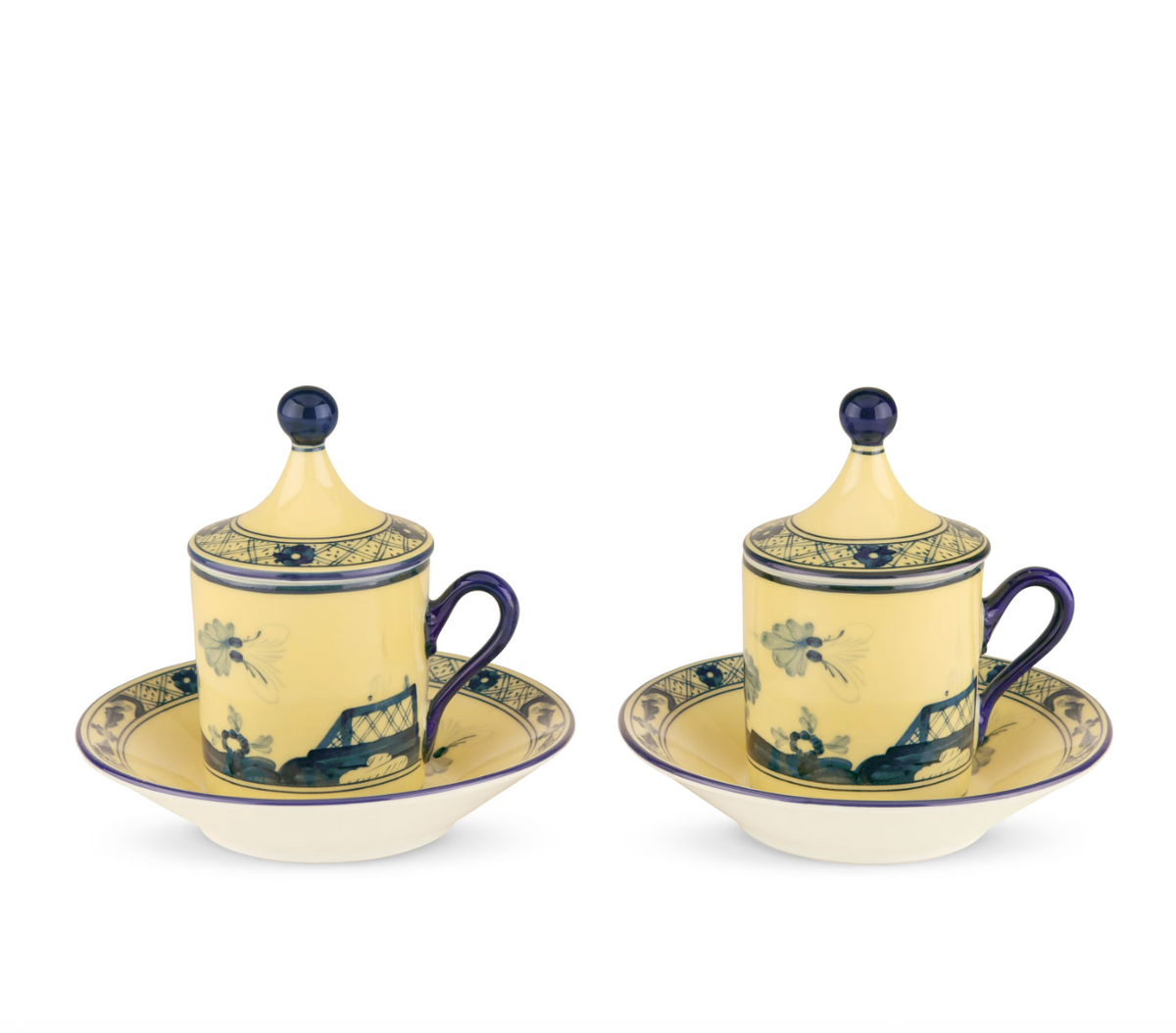 Two pale yellow Ginori 1735 Oriente Italiano Dinnerware Citrino lidded teacups with blue floral patterns, each resting on a matching saucer.