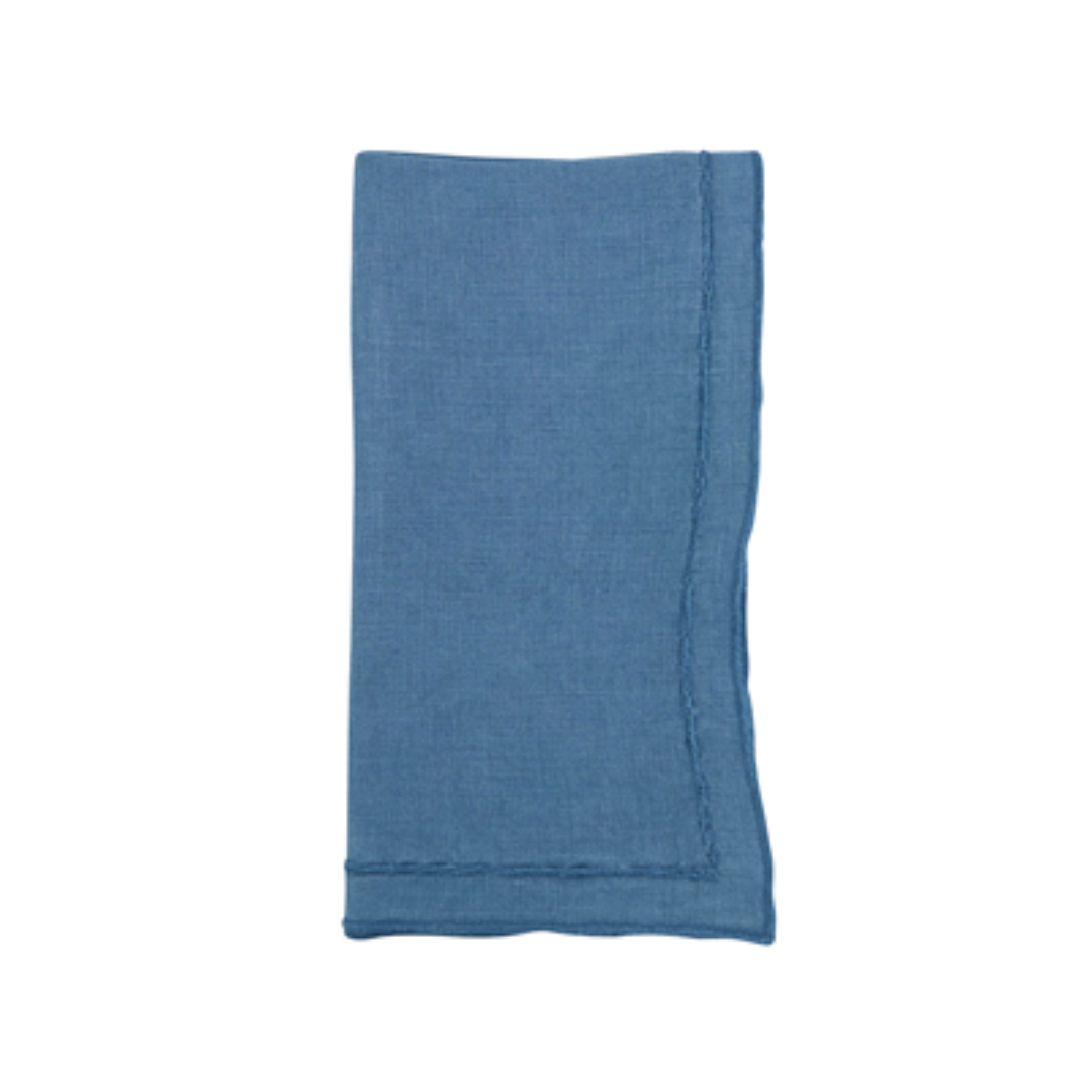 A single blue Overlock Stonewash Border Napkin by Saro Trading, neatly folded with slightly frayed edges, is displayed on a white background.