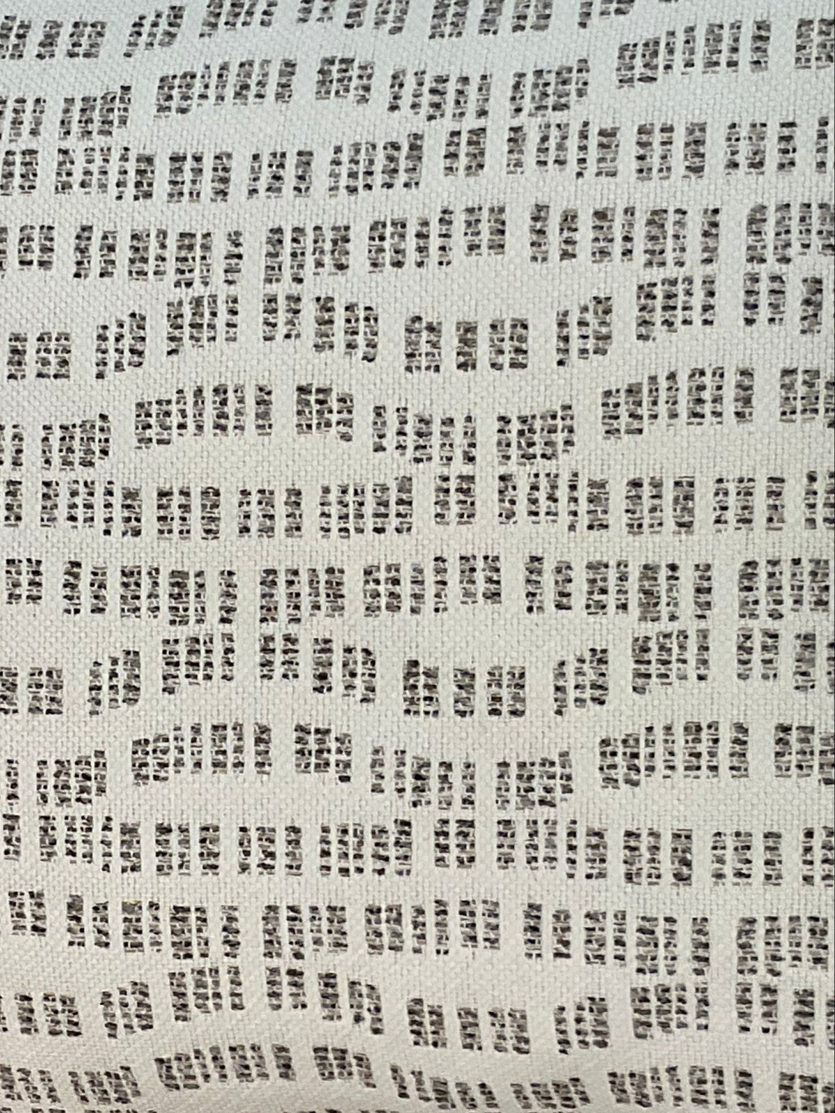 Close-up of the Pebble Path Linen Pillow by Decor Fifty-Five, shown against a white background. Its pattern of small, irregular black rectangular dashes in rows offers a perfect neutral touch for subtle style.