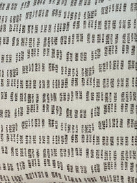 Close-up of the Pebble Path Linen Pillow by Decor Fifty-Five, shown against a white background. Its pattern of small, irregular black rectangular dashes in rows offers a perfect neutral touch for subtle style.