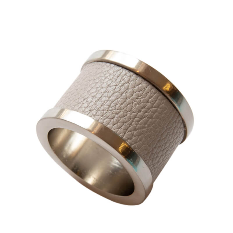 The Von Gern Home Zinc & Leather Napkin Ring S/4 features a cylindrical shape with a textured light gray leather exterior and shiny silver metal edges, shown on a white background.