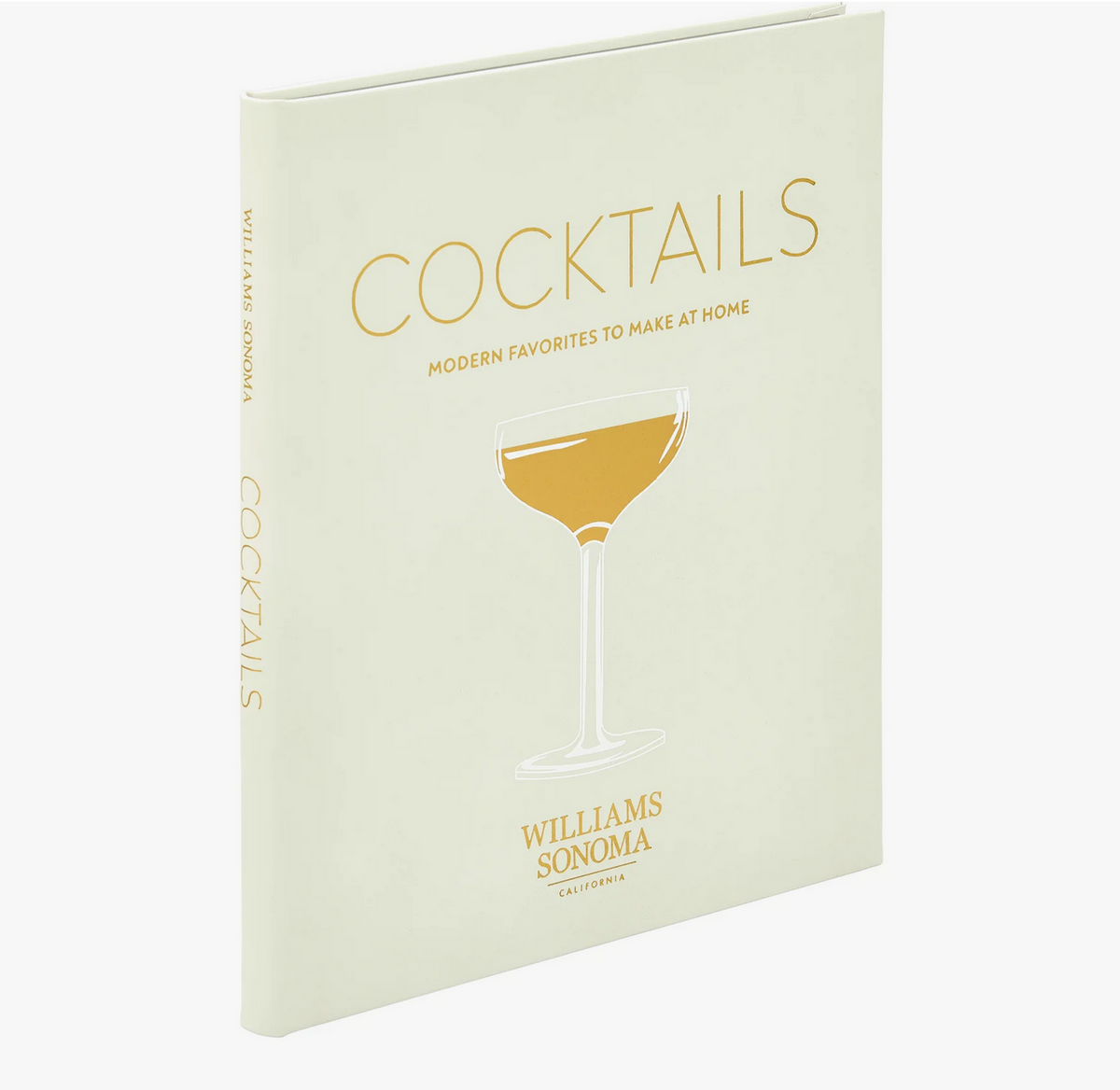 A cream-colored hardcover Leather Book - Cocktails by Graphic Image, featuring a gold cocktail glass illustration, filled with classic cocktail recipes and essential mixology techniques.