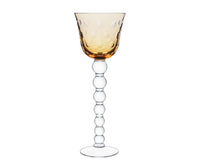 The Bubbles Hock Stemware by Saint-Louis features an amber dimpled bowl, a clear stem of stacked glass spheres, and a flat base—a striking design inspired by contemporary Saint-Louis crystal tableware.