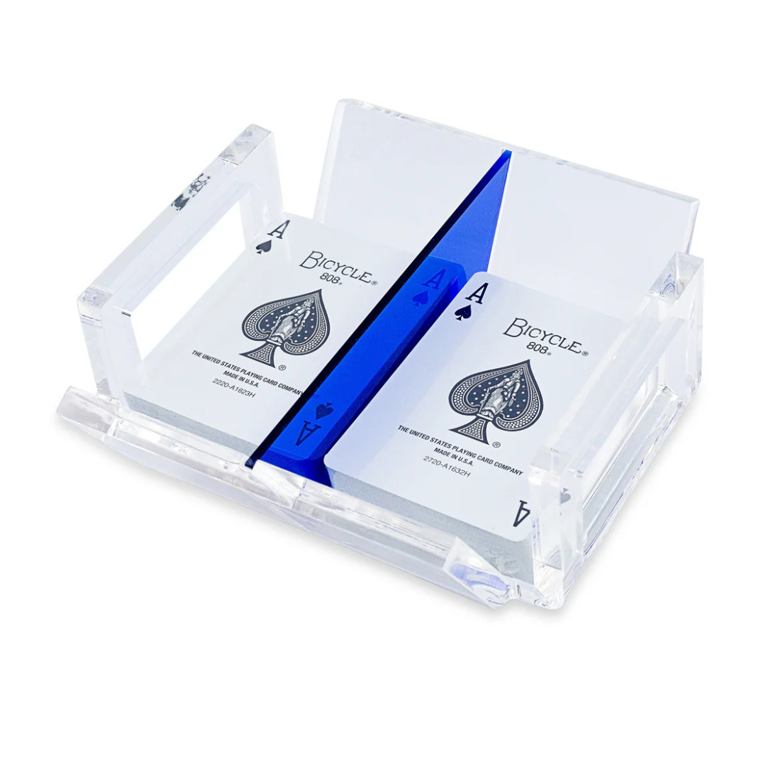 The Luxe Dominoes El Canasta Tray is a clear acrylic playing card tray with a blue divider that holds two decks of Bicycle cards, each showing the Ace of Spades—perfect for game night or as a canasta accessory.