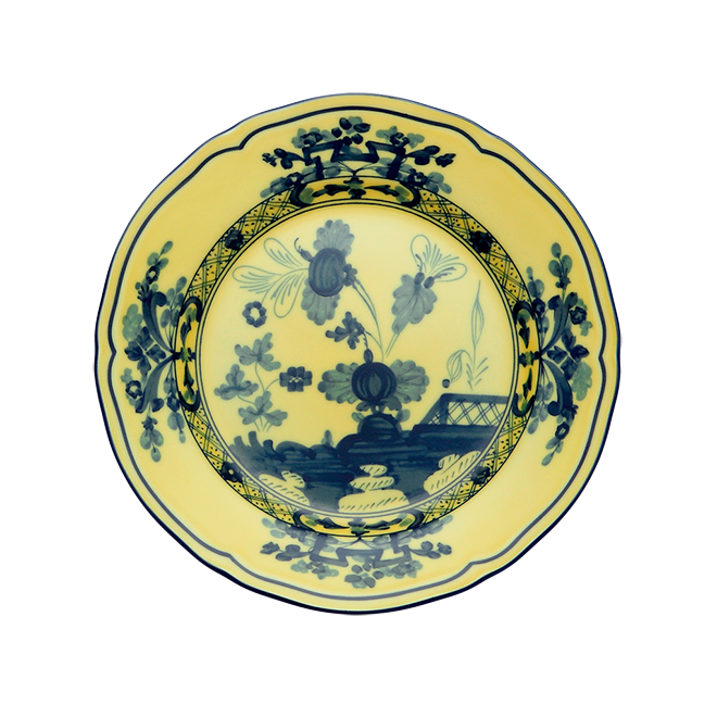 The Oriente Italiano Dinnerware Citrino by Ginori 1735 is a round ceramic plate with a yellow background, featuring intricate blue floral and geometric chinoiserie-inspired patterns in the center and along the rim.
