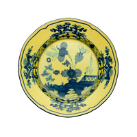 The Oriente Italiano Dinnerware Citrino by Ginori 1735 is a round ceramic plate with a yellow background, featuring intricate blue floral and geometric chinoiserie-inspired patterns in the center and along the rim.