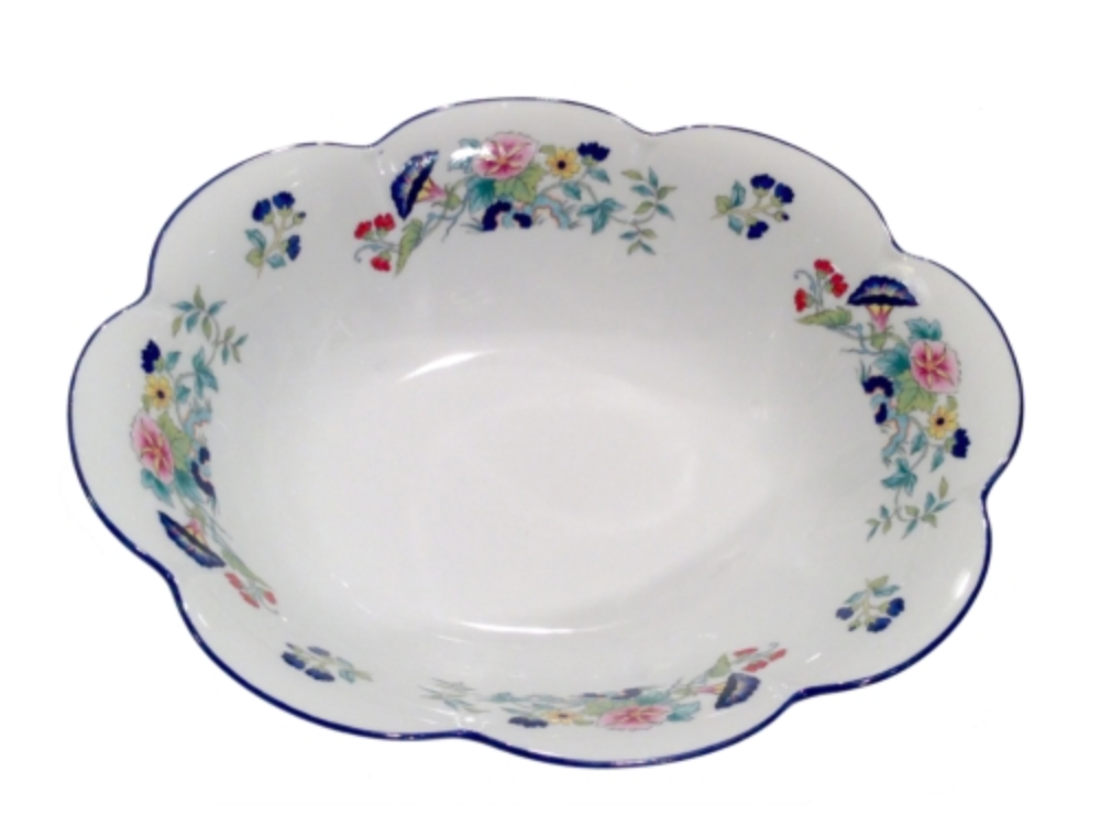 The Nymphea Paradis Bleu bowl by Royal Limoges is a white ceramic piece with scalloped edges, colorful floral patterns, and blue accents around the rim, inspired by classic porcelain design.
