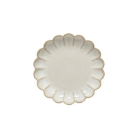 The Marrakesh Dinnerware White plate by Casafina/Costa Nova is a small, round ceramic plate with scalloped flower-like edges and a subtly speckled cream surface, reflecting Moroccan-inspired elegance. Displayed on a white background.