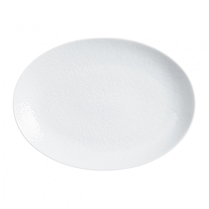 The Raynaud Mineral Dinnerware Glazed White plate features a plain, white, oval-shaped Limoges porcelain design with a subtle textured pattern, displayed on a white background.