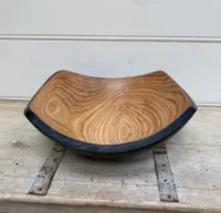 The Peterman Two Toned Square Oak Wood Bowl features a square rim, rounded edges, natural oak grain, and a dark outer edge. Food safe and beautifully presented on rustic wood—perfect for stylish serving.