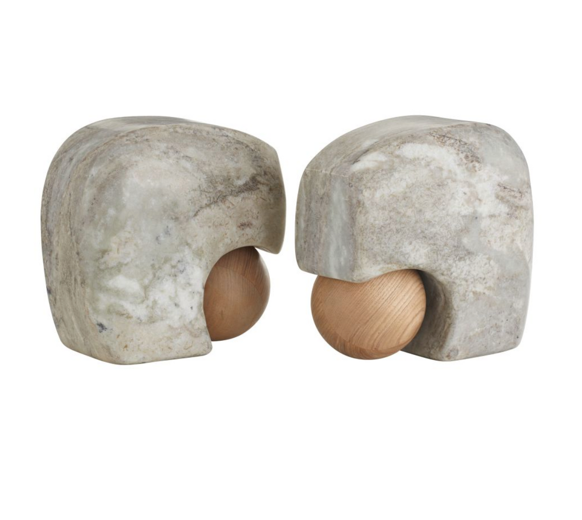 A pair of Arteriors Melt Bookends Set of 2, crafted from mottled gray stone and featuring a wooden sphere partly nestled within each hollowed form, are displayed facing one another against a plain white background. These distinctive bookends seamlessly blend natural textures for an artful accent on any shelf.