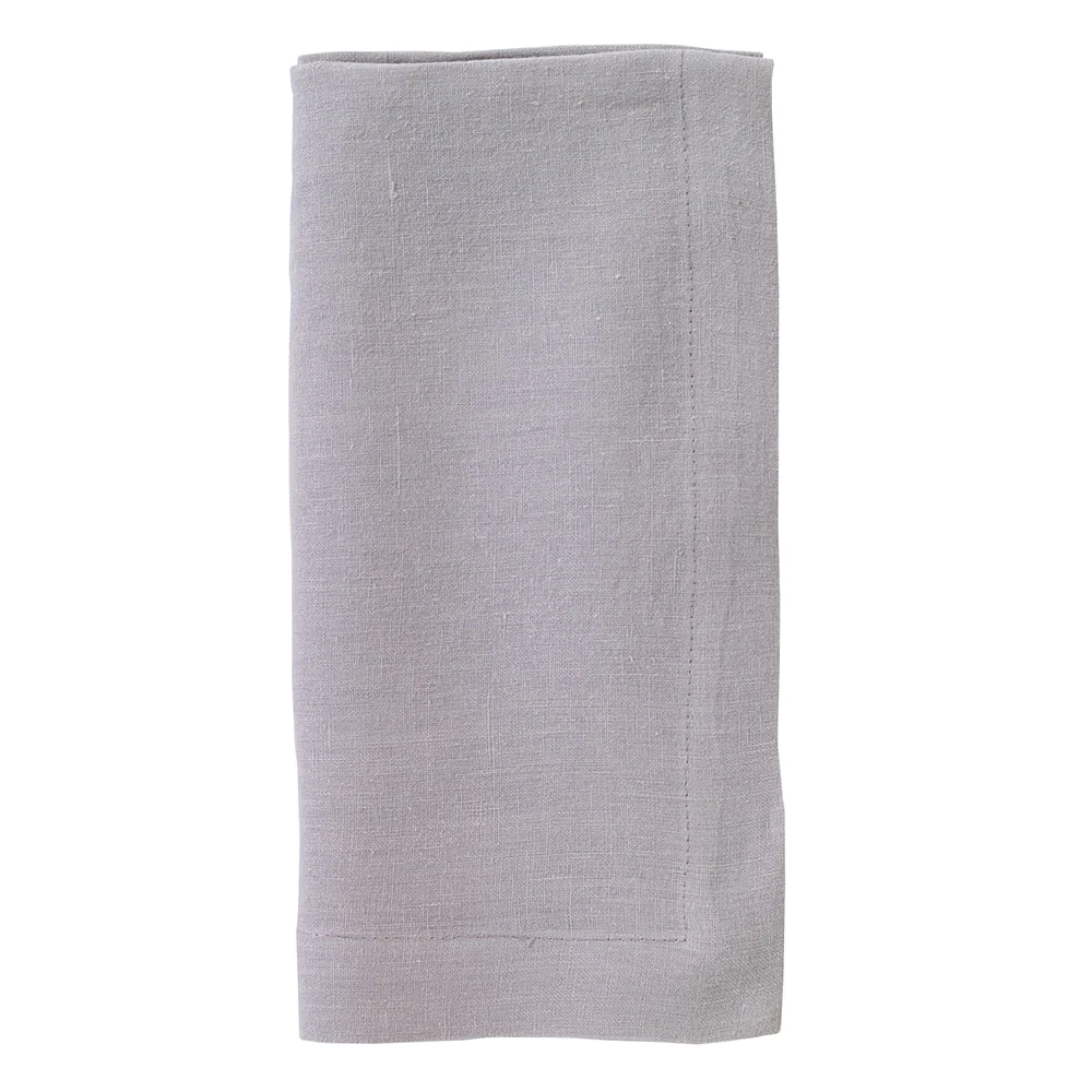 A set of four Riviera napkins by Bodrum, made from light gray stone-washed linen with a simple stitched border, neatly folded and displayed against a white background.