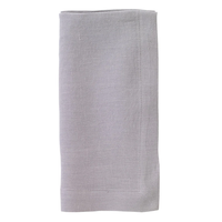 A set of four Riviera napkins by Bodrum, made from light gray stone-washed linen with a simple stitched border, neatly folded and displayed against a white background.