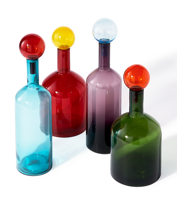 The Bubble Bottles Multi Color Set of 4 by Polspotten features mouth-blown glass bottles in blue, red, green, and purple, each with a unique colored spherical stopper, arranged like vibrant ornaments on a white background.
