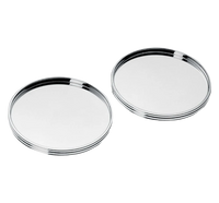 The Christofle K+T Two Silver-Plated Coasters, inspired by Adam D. Tihany, have a shiny, round design with raised edges and are displayed side by side on a plain white background.