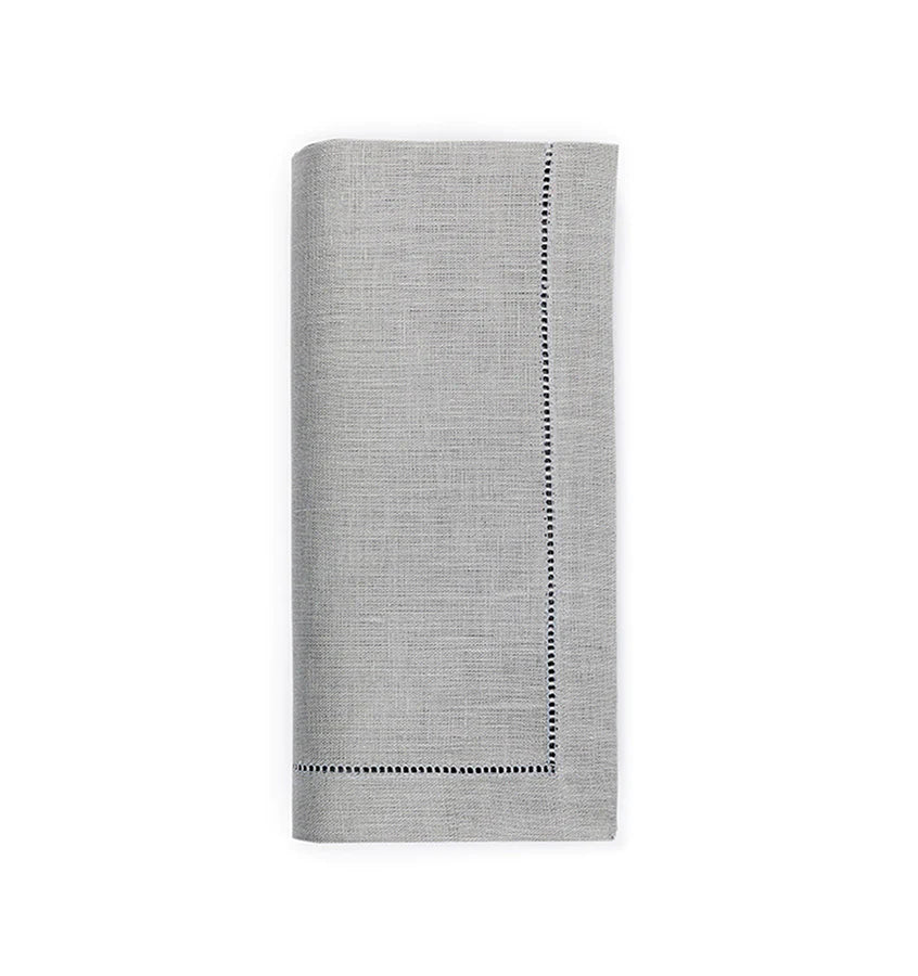A set of four light gray Sferra Festival Napkins, each neatly folded with subtle texture and decorative stitched borders on two sides, displayed on a white background.