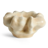 The Timna Coupe - Latte by L’Objet is a cream-colored ceramic bowl featuring a wavy, sculpted rim and organic, irregular shapes reminiscent of a flower or abstract form—evoking the elegance of fine porcelain and making it an ideal addition to any luxury gift box.