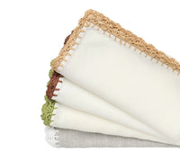 The Kim Seybert Shell Edge Napkin Set of 4 features folded linen napkins with stitched edges and hand-crocheted raffia trim in tan, brown, green, and white—ideal for creating a rustic table setting.