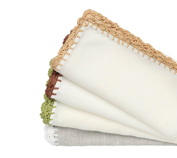 The Kim Seybert Shell Edge Napkin Set of 4 features folded linen napkins with stitched edges and hand-crocheted raffia trim in tan, brown, green, and white—ideal for creating a rustic table setting.