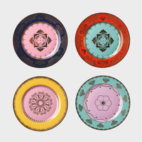 The Polspotten Grandpa Canape Plates Multi Set of 4 includes porcelain side plates with unique central designs: navy/pink (top left), red/light blue (top right), yellow/pink (bottom left), and turquoise/lilac (bottom right).