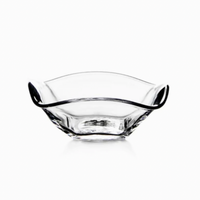 The Simon Pearce Woodbury Bowl is a clear handblown glass bowl with a wavy, asymmetrical rim and smooth edges, ideal for serving salad. Photographed on a white background.