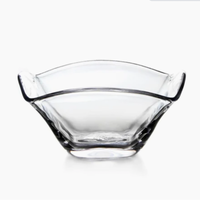 The Simon Pearce Woodbury Bowl, handblown from clear glass with a wavy, scalloped rim and square base, is displayed against a white background—ideal as an elegant salad bowl.
