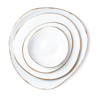 Four irregularly shaped white Simply Gold Dinnerware plates by Molecot, each with gold rims, are stacked concentrically from largest to smallest and viewed from above on a white background.