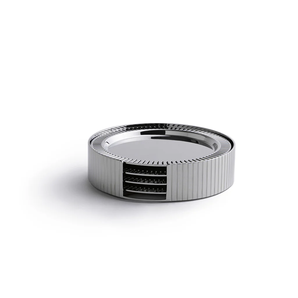 The Anna New York Striations Silver Coasters Set of 4 in Holder features round, ribbed metal coasters with exposed inner layers, resembling modern stainless steel, displayed on a white background.