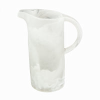 The Nashi Home Swirl Resin Classic Pitcher is a tall, translucent white pitcher with a marbled swirl pattern, curved spout, and rounded handle. It's shatterproof, dishwasher safe, and shown against a plain white background.