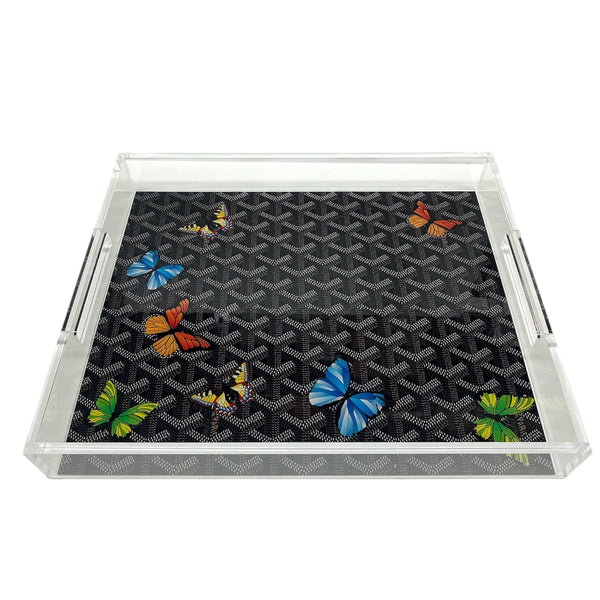 The Eye Candy Grandeur Tray - Maison Black w/ Butterflies 14 x 18 is a clear acrylic tray with silver handles and a black patterned base featuring vibrant butterflies—ideal as a stylish decorative serving tray for any event.