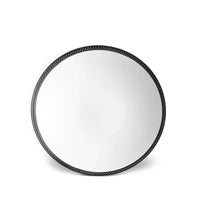 A round mirror with a black, braided frame accents any space and pairs beautifully with L'Objet Soie Tressée Black Dinnerware for a refined, sophisticated dining atmosphere.
