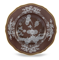 A decorative brown plate with scalloped edges, gold trim, and white floral designs from the Oriente Italiano Castagna collection by Ginori 1735, made in Italy.