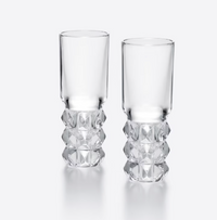 The Louxor Vodka Set of 2 by Baccarat—featuring diamond-cut crystal bases and smooth upper sections—is displayed side by side against a light background.