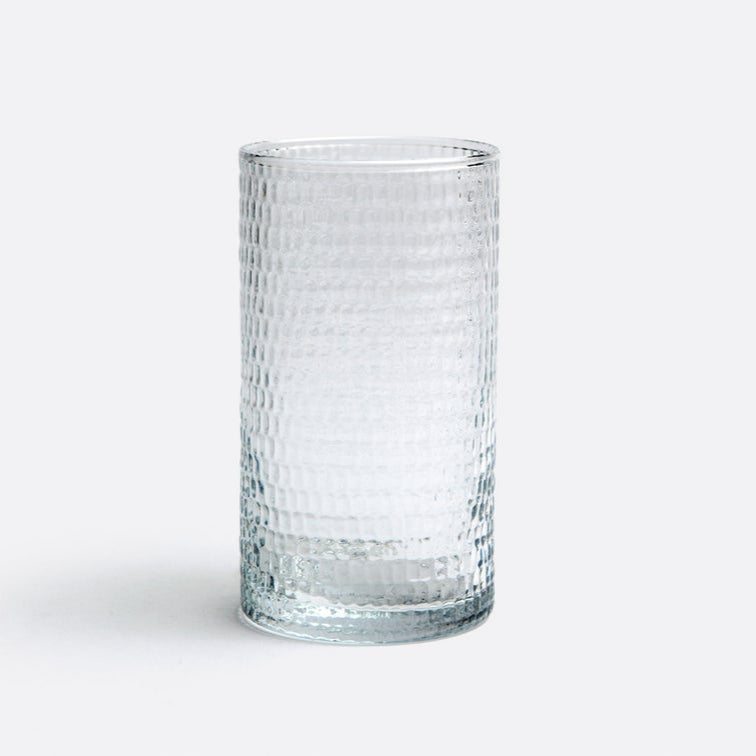 The Duncan Glassware Clear by Blue Pheasant is a hand-blown glass with a textured grid-like pattern, shown upright on a white surface and light gray background—ideal for everyday use.