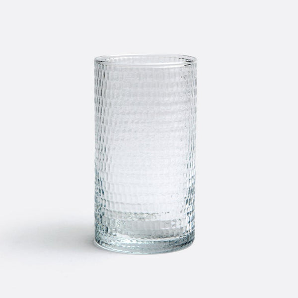The Duncan Glassware Clear by Blue Pheasant is a hand-blown glass with a textured grid-like pattern, shown upright on a white surface and light gray background—ideal for everyday use.