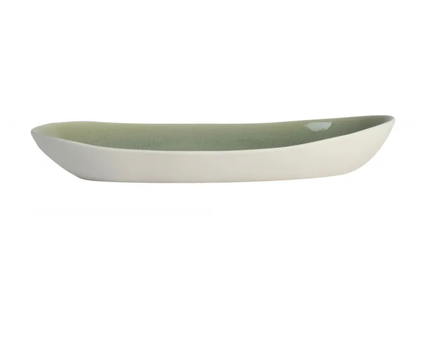The Maguelone Cachemire Dinnerware by Jars - Rosenthal is a long, oval ceramic dish with a white exterior and light green interior. Shown from the side on a white background, this handmade piece is dishwasher safe for easy cleaning.