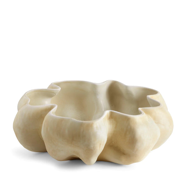The Timna Bowl Latte by L'Objet is a sculptural, cream-colored porcelain vessel with an organic, wavy rim, hand-sculpted to resemble a flower or coral, set against a white background.