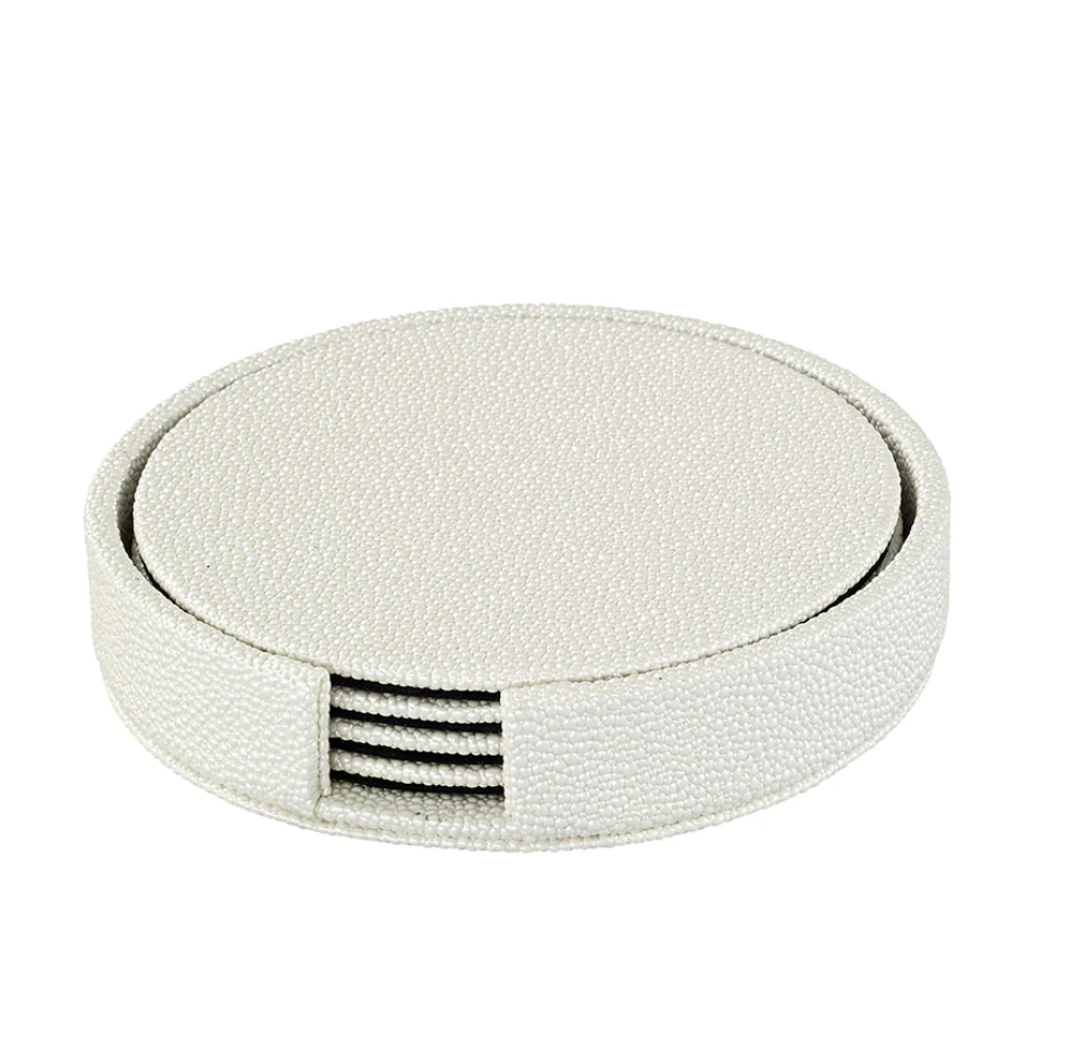 The Bodrum Skate Coaster Set of 4 features round textured white coasters crafted from phthalate-free vinyl, neatly stacked in a matching holder with an open side for easy access—combining style and safety for your tabletop.
