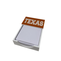 The Eye Candy College Note Pad features square white notepaper in a white holder, topped with a brown cover labeled TEXAS in large white letters—a distinctive graduation gift.