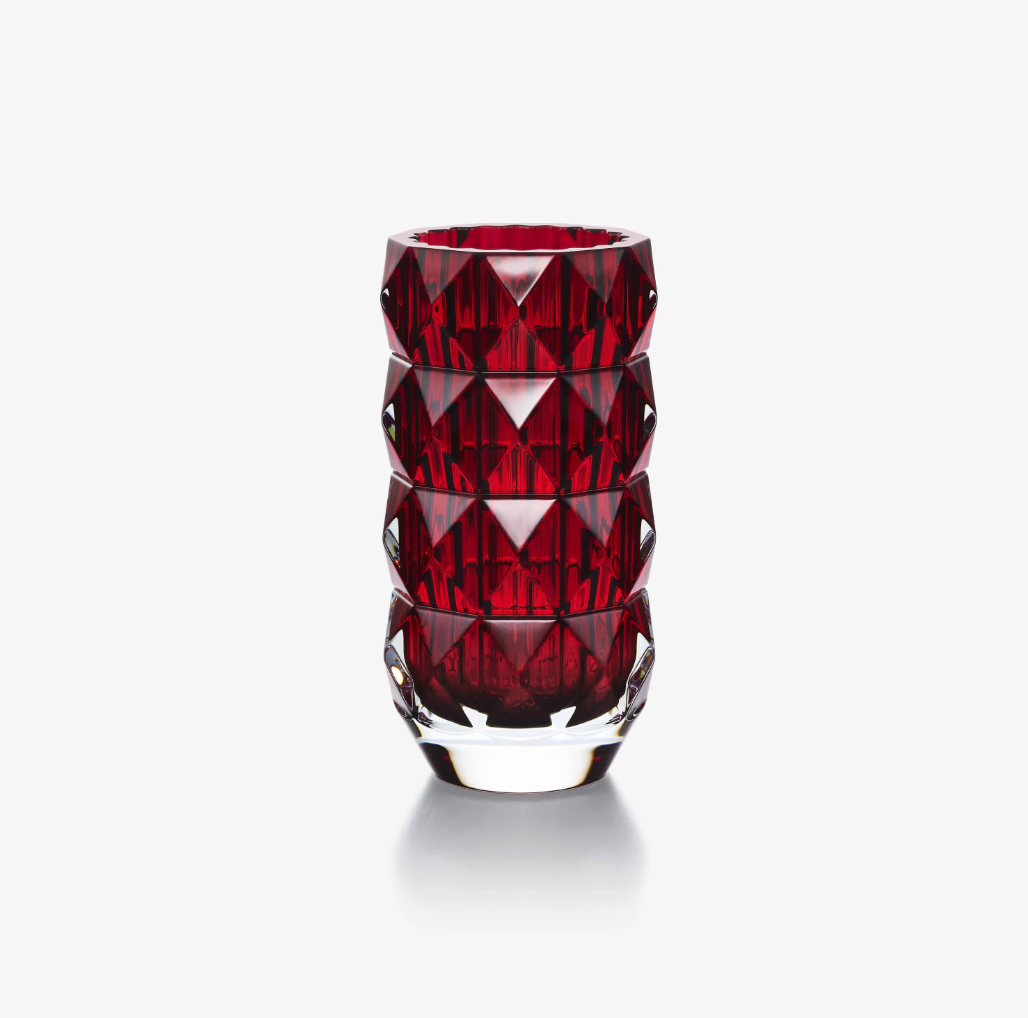 The Baccarat Louxor Round Vase Red features deep red, faceted crystal and geometric diamond patterns that reflect light, showcased upright on a plain white background.