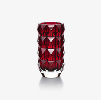 The Baccarat Louxor Round Vase Red features deep red, faceted crystal and geometric diamond patterns that reflect light, showcased upright on a plain white background.