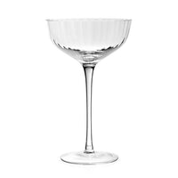 The Corinne Drinkware coupe glass by William Yeoward features a wide, shallow bowl, thin stem, and round base—ideal for modern barware fans. Shown empty against a plain white background.