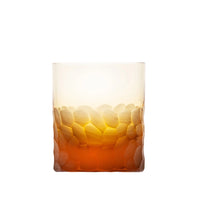 The Moser Pebbles DOF 370 ml is a hand-blown, lead-free Czech crystal whisky glass with a textured pebble base that fades from amber orange to clear, shown empty against a white background.