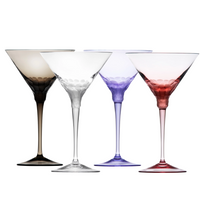 Four Pebbles Martini Glasses by Moser (260 ml each) in black, clear, purple, and red crystal glass stand side by side, each hand-cut with a unique dimpled pattern—exceptional handcrafted drinkware.