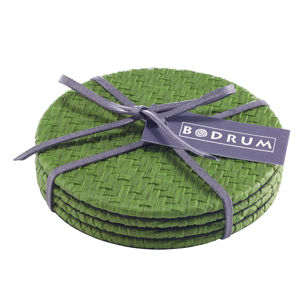 The Bodrum Wicker Easy Care Coaster Set includes four round green woven wicker coasters with felt backing, tied with a gray ribbon and finished with a rectangular Bodrum brand tag.