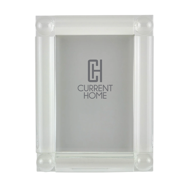 The Tizo Corner Ball Crystal Frame Clear is a luxury acrylic picture frame with four rounded corner pillars, featuring the Current Home logo in the center on a gray background.