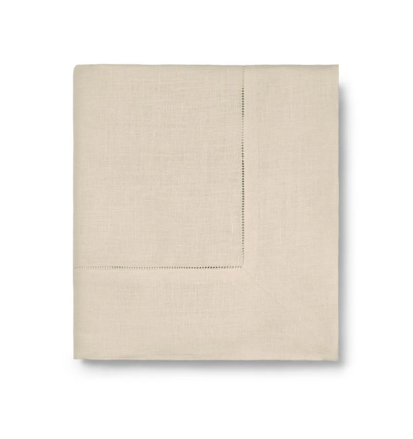 The Sferra Festival Tablecloth in light beige features a simple hemstitch border and is neatly displayed on a white background.