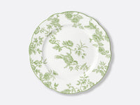 The Albertine Dinnerware by Bernardaud is a white porcelain plate with scalloped edges, adorned with ornate green floral and bird motifs inspired by classic toile de Jouy—a poetic nod to iconic Bernardaud design.