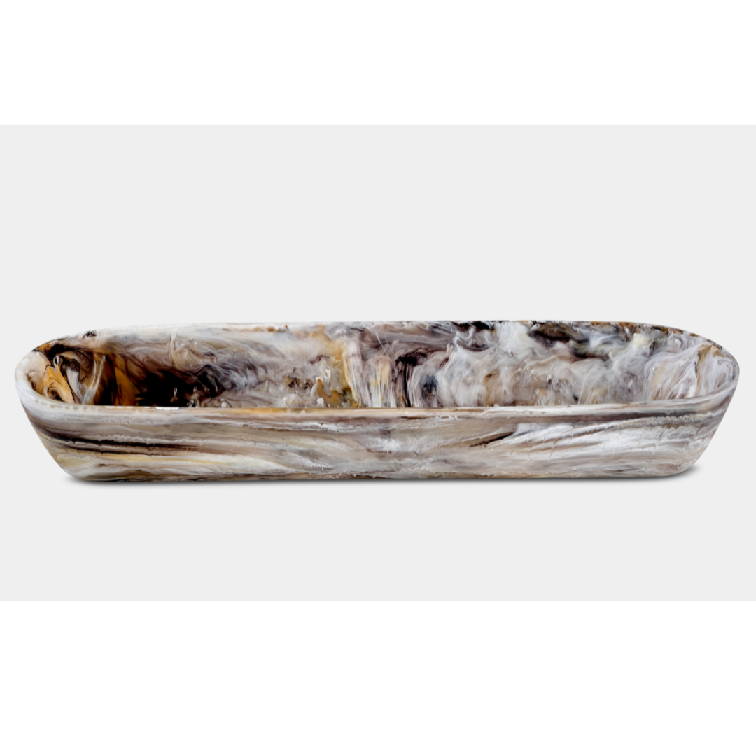 The Nashi Home Swirl Resin Colored Boat Bowl Mocha features a long, oval shape and marbled brown, black, gray, and white design. Shatter resistant and ideal for elevating home décor, shown on a plain white background.