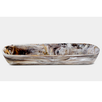 The Nashi Home Swirl Resin Colored Boat Bowl Mocha features a long, oval shape and marbled brown, black, gray, and white design. Shatter resistant and ideal for elevating home décor, shown on a plain white background.